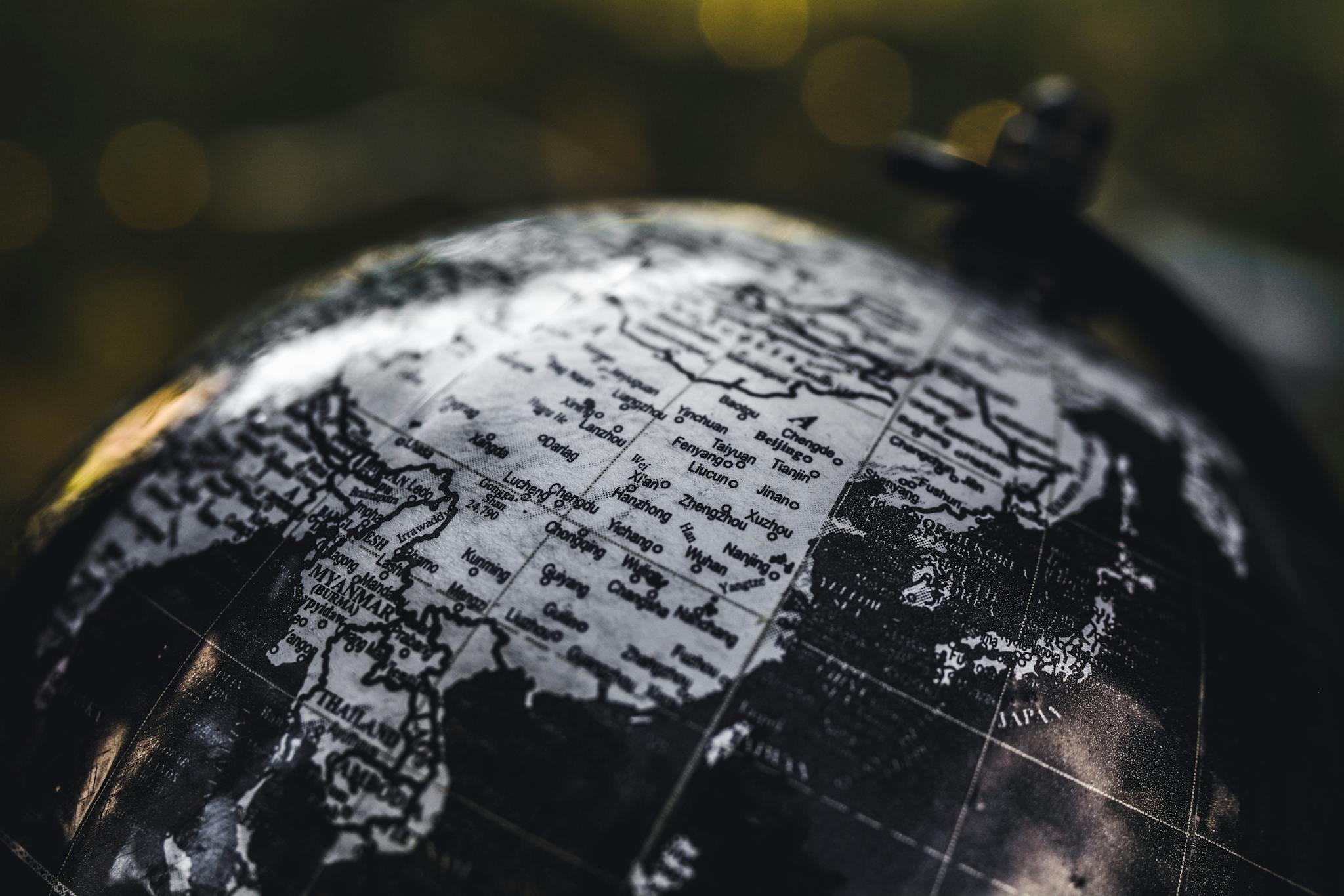 Detailed black and white close-up image of a globe focusing on Asia, highlighting geographical details.